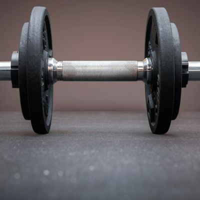 Iron dumbbells on a dark reflective floor